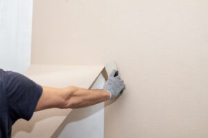 removing wallpaper from the wall with a spatula