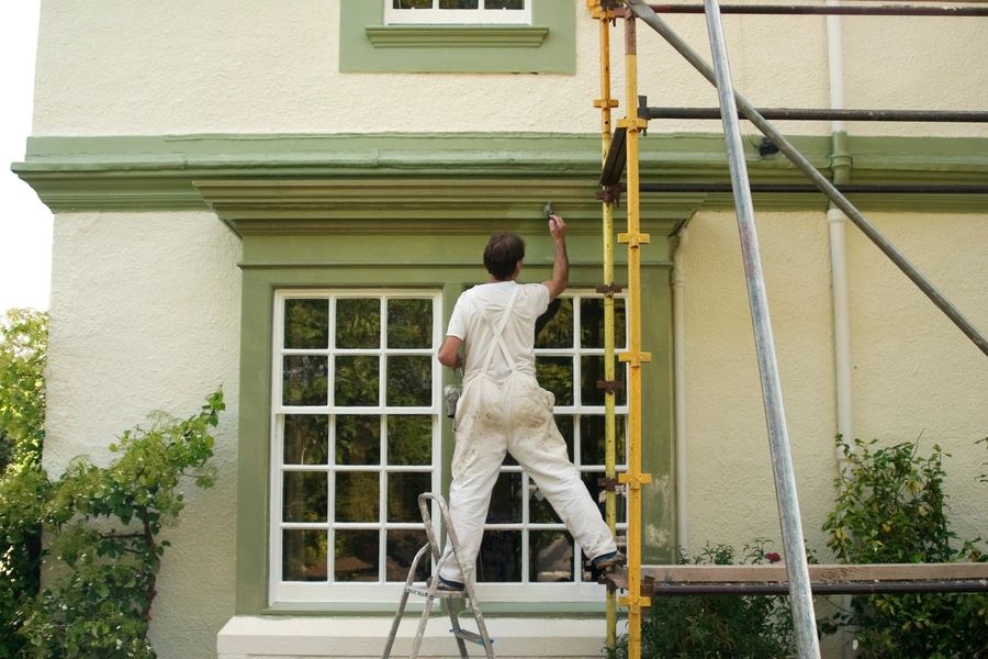 man painting house exterior