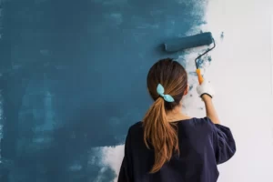 woman painting wall blue